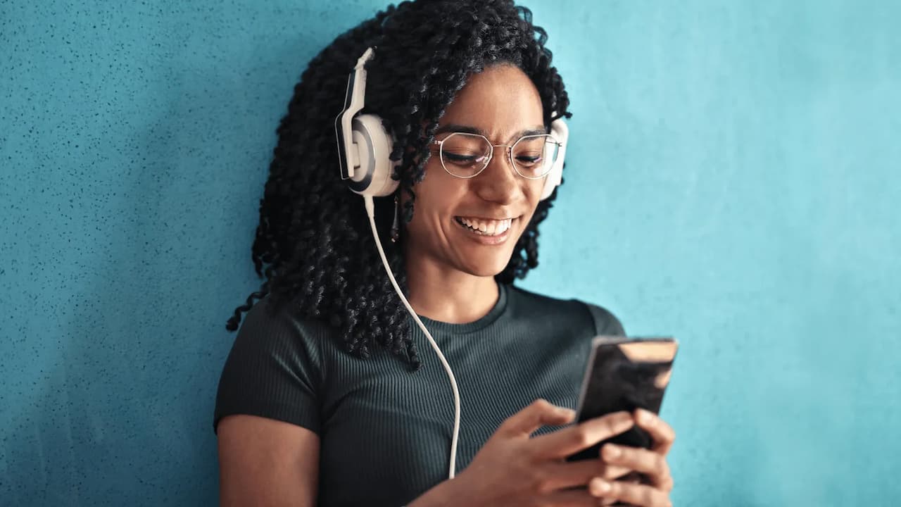 Chica-escucha-musica-mira-telefono-movil-feliz Chica-escucha-musica-mira-telefono-movil-feliz