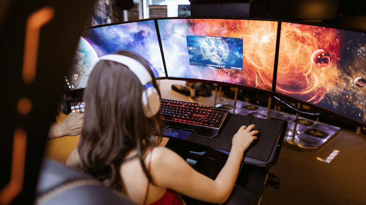 Chica-jugando-ordenador-varios-monitores-gaming Chica-jugando-ordenador-varios-monitores-gaming