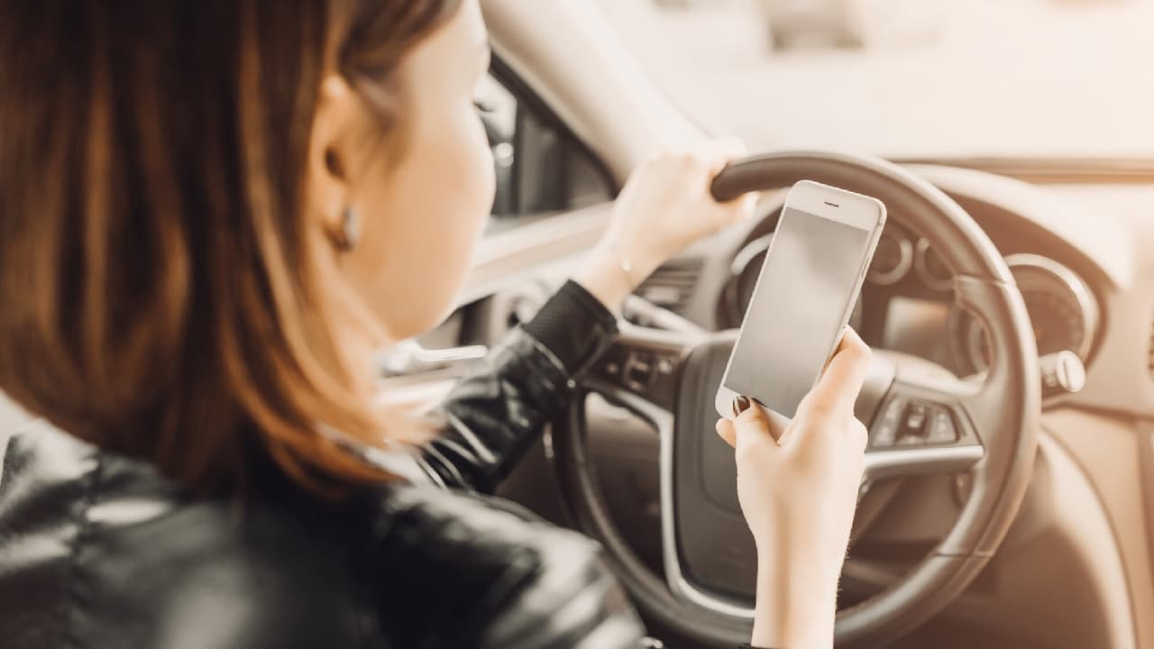 Mujer-usando-movil-en-coche-min Mujer-usando-movil-en-coche-min