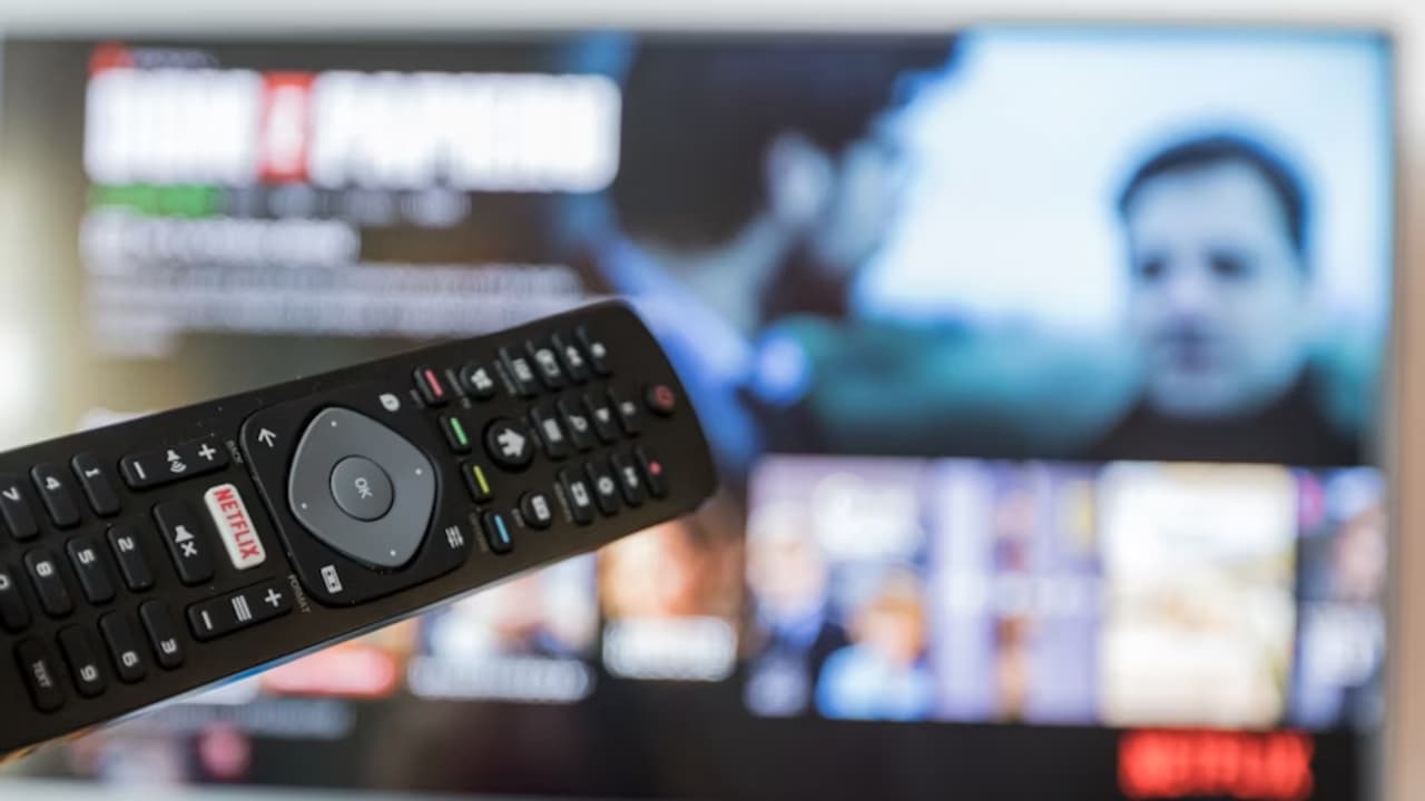 Un-mando-de-Smart-TV-con-tele-de-fondo Un-mando-de-Smart-TV-con-tele-de-fondo